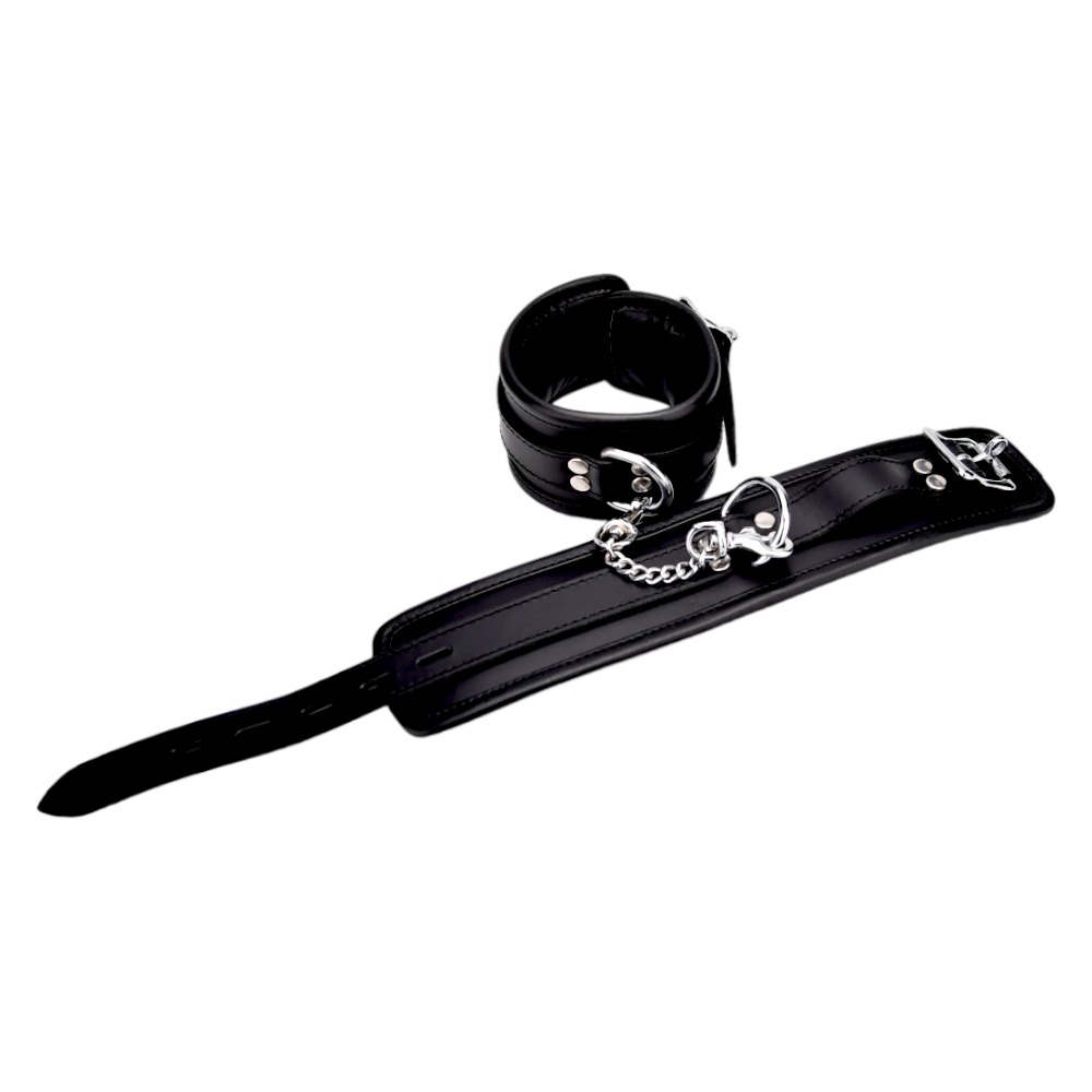 Bound Leather Wrist Restraints, Padded black leather wrist cuffs with silver trims joined by a short metal chain