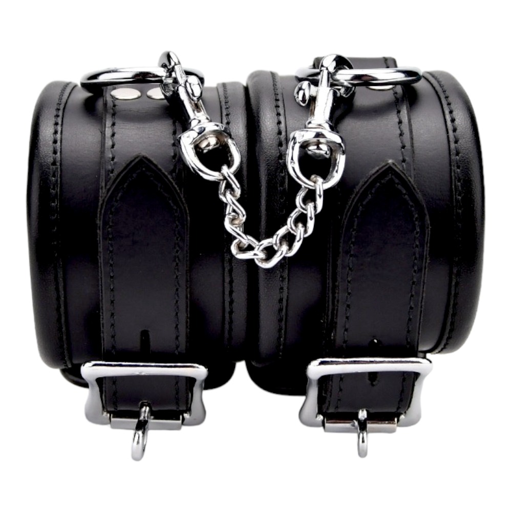 Bound Leather Wrist Restraints, Padded black leather wrist cuffs with silver trims joined by a short metal chain